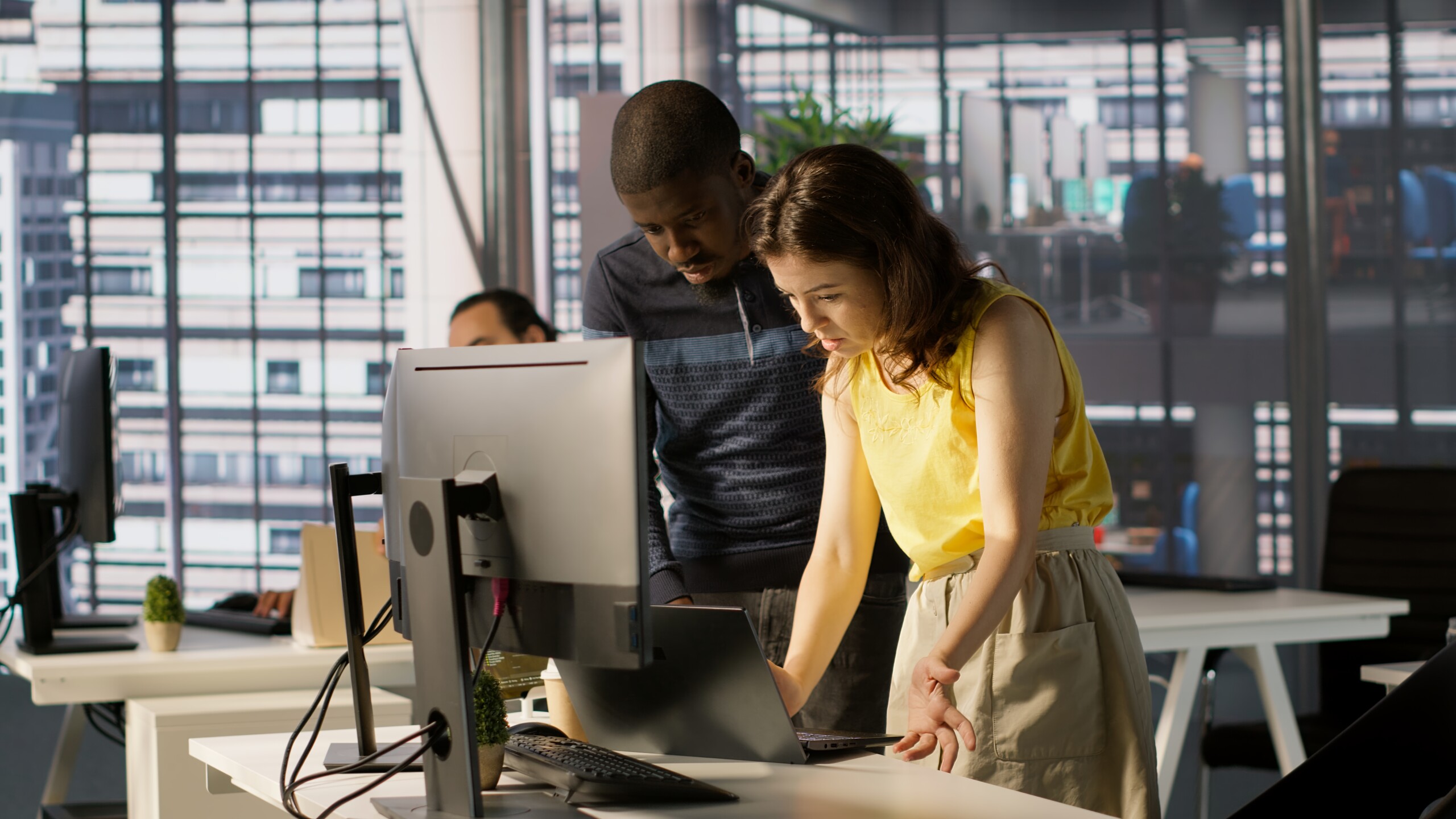 Two IT professionals collaborating on a project at a computer workstation. Two IT professionals collaborating on a project at a computer workstation.